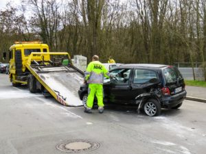 Accident car being pulled onto a flatbed tow truck 